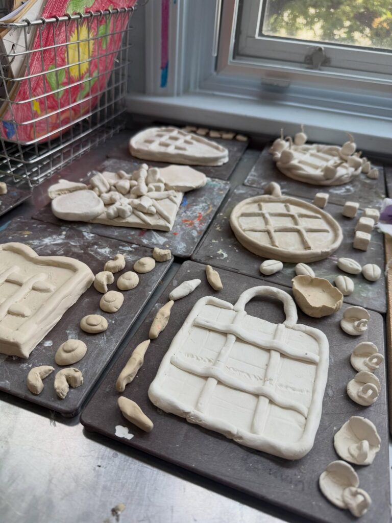 Air dry clay ornaments resting on dark tiles by a bright window sill.