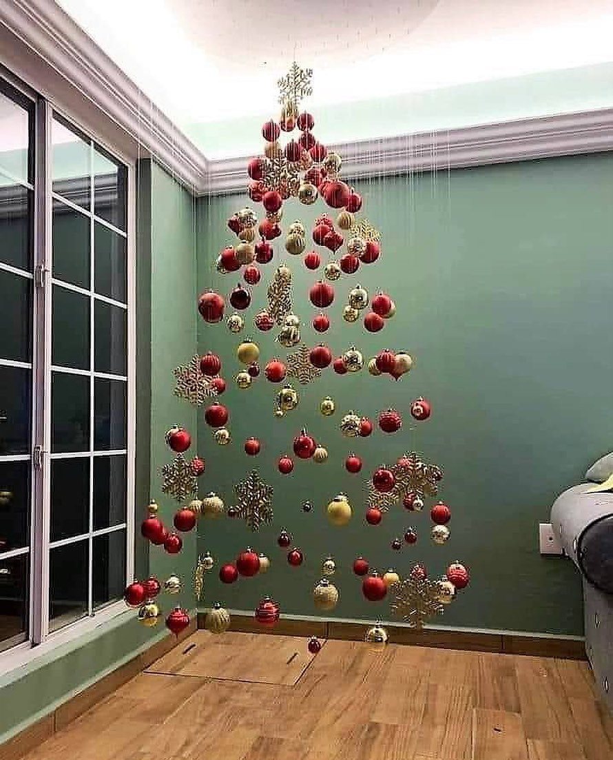 Christmas ornaments hanging from the ceiling arranged in the shape of a tree.