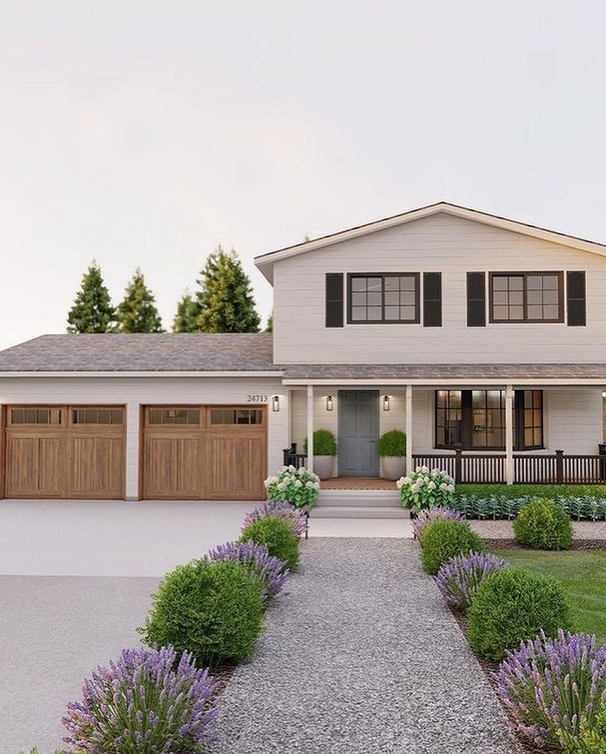 A gravel walkway lined with lavender and shrubs leading to a modern two-story house.