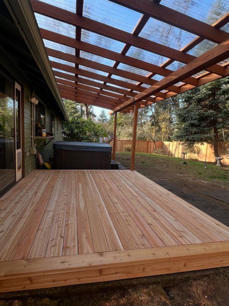 A new wooden deck with a large wooden pergola and translucent roof attached to a house.