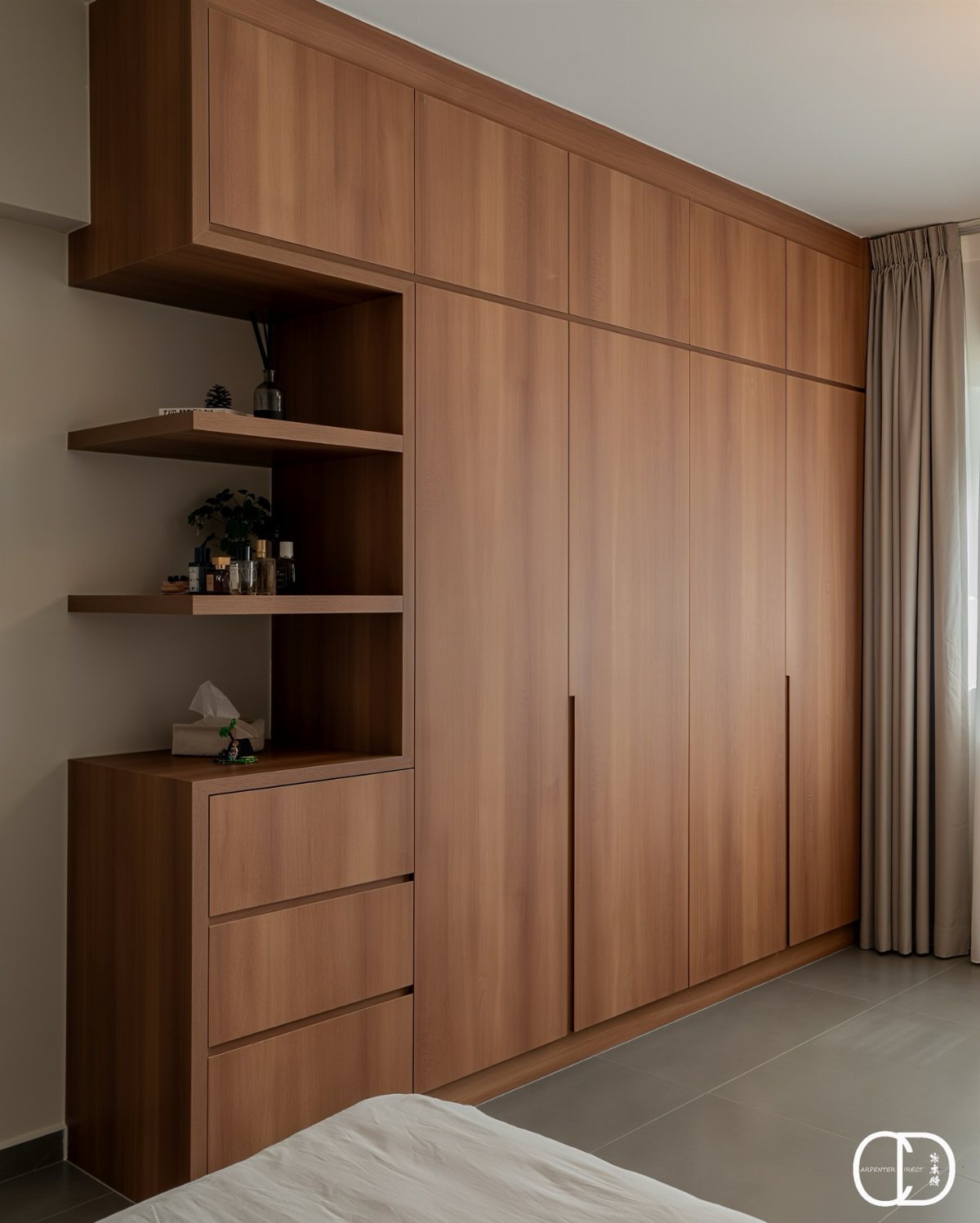 Wooden wardrobe with sliding doors and integrated open shelves containing small decorative items and drawers.